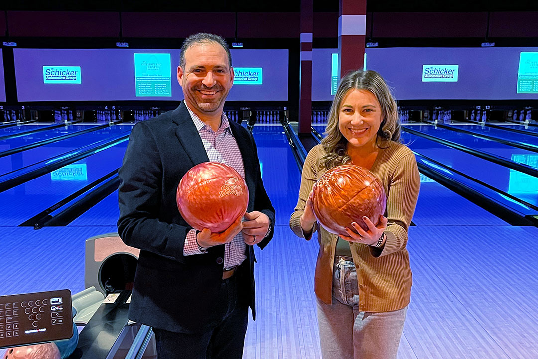 Josh Margolis and Joanna holding bowling balls at BackStoppers Bowling for Badges.