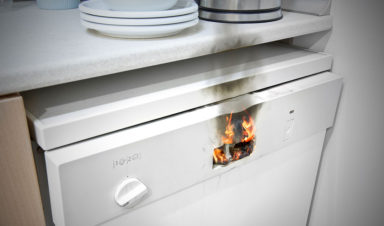 A fire has started in the panel of a white dish washer, leading to potential product liability claims.