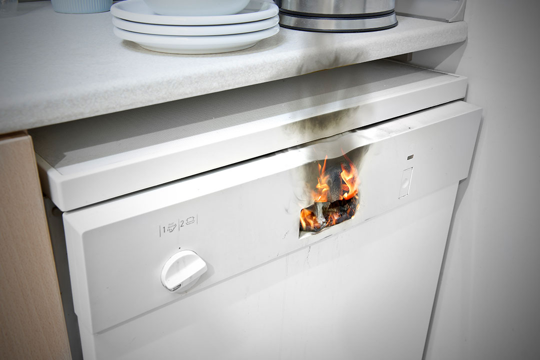 A fire has started in the panel of a white dish washer, leading to potential product liability claims.
