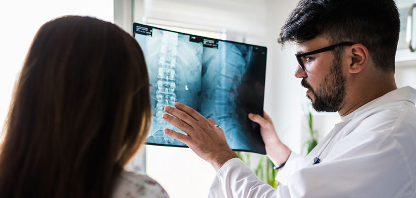 doctor reading x-ray to patient and discussing traumatic injury to the spinal cord