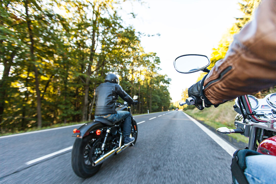 man in black jacket riding a motorcycle with his friend
