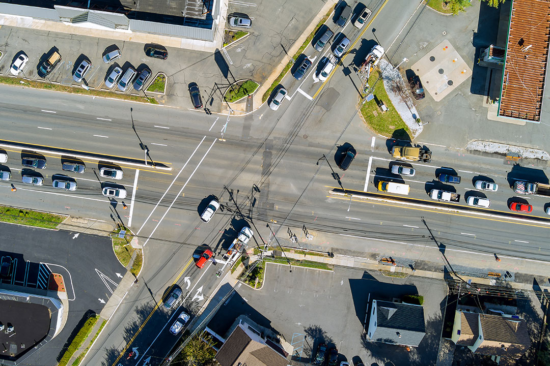 A birds-eye view of a dangerous intersection, with cars coming from all directions