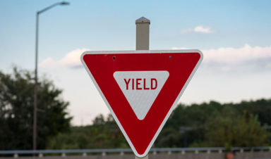 photo of a red yield sign next to a road