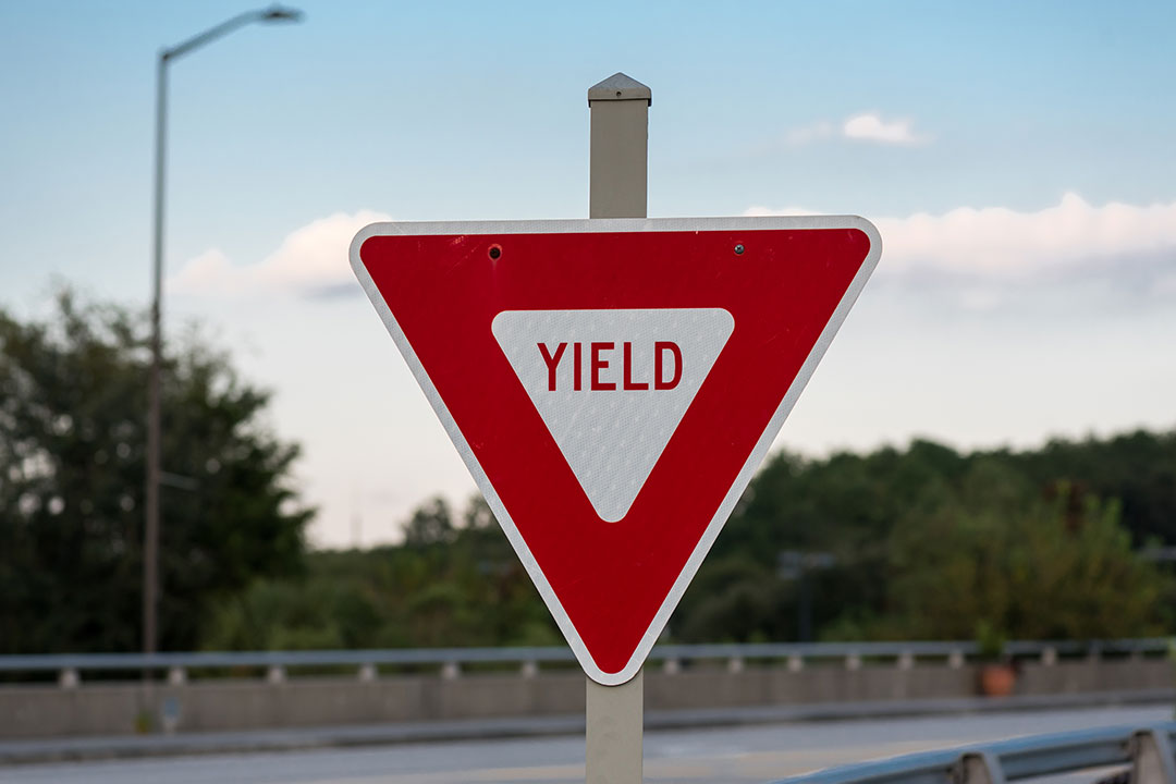 photo of a red yield sign next to a road